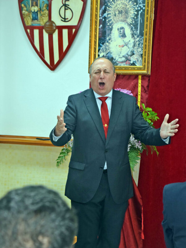 Hombre en traje hablando con entusiasmo en un evento formal.