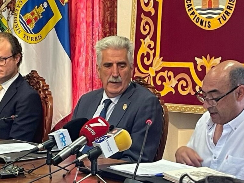 Conferencia de prensa en el Ayuntamiento de Cádiz, con autoridades locales y medios de comunicación presentes.