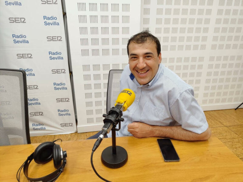 Entrevista en Radio Sevilla, SER2, con un entrevistado sonriente en un estudio de radio.