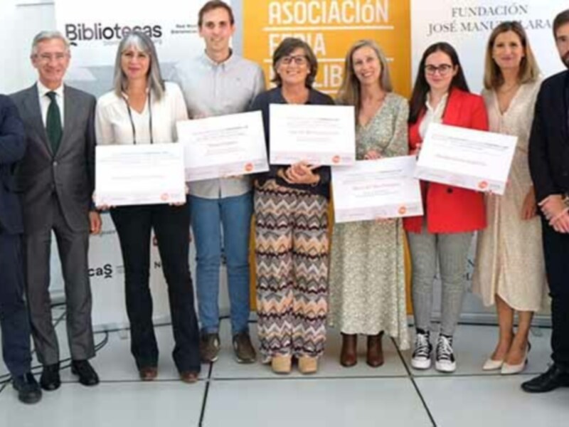 Equipo de profesionales posando con sus reconocimientos en una conferencia de bibliotecas.