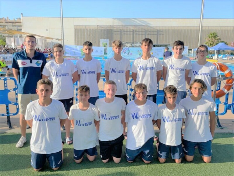 Equipo de waterpolo juvenil posando en la piscina al aire libre