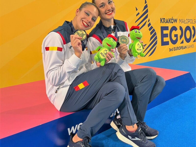 Dos atletas celebran su victoria en los Juegos Europeos de 2021 en Cracovia, Polonia, con medallas y peluches del evento.