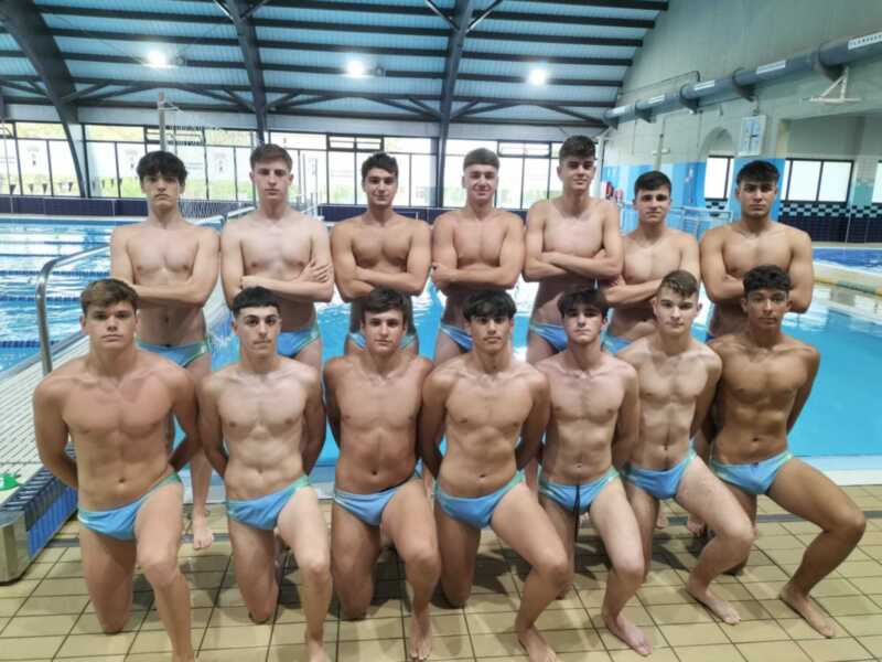 Equipo de natación juvenil en una piscina cubierta.