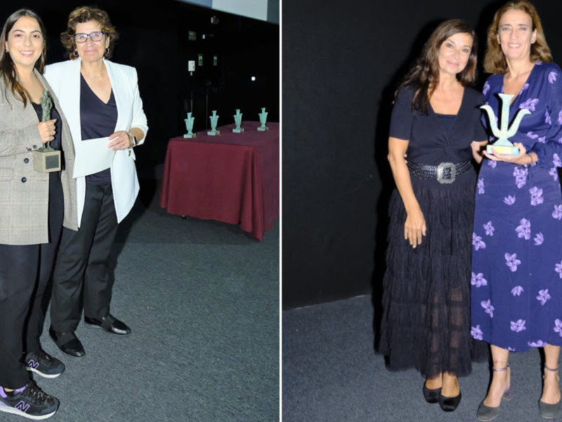 Premio a la Excelencia en Eventos: Dos mujeres celebran un logro con un trofeo en una ceremonia formal.
