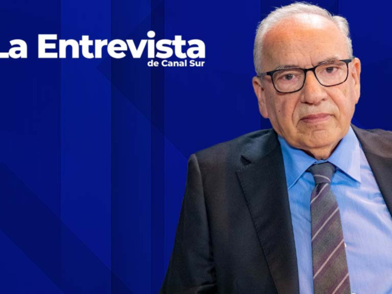 Entrevista de Canal Sur con un invitado en traje y corbata.