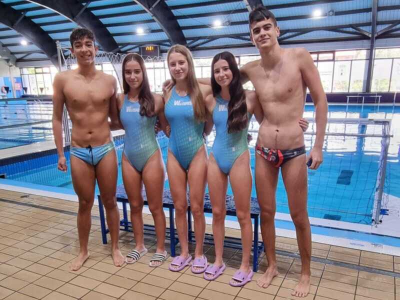Equipo de natación posando junto a la piscina.