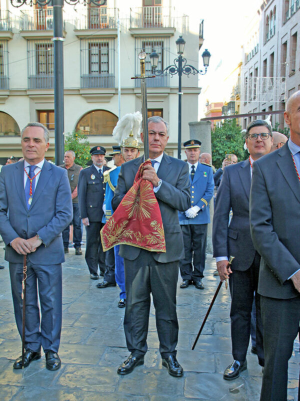 Oficiales y autoridades en una ceremonia oficial en una plaza histórica.