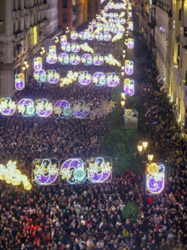 Fiesta navideña con luces y multitud en la calle de noche