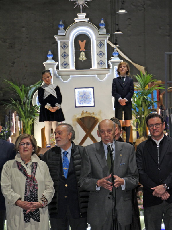 Celebración en una iglesia con un altar decorado y personas en trajes formales.
