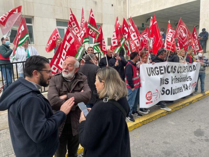 Manifestación sindical con banderas rojas y pancarta que pide soluciones urgentes para los trabajadores.