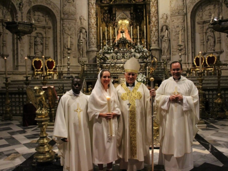 Celebración eclesiástica en una catedral con sacerdotes y un altar ornado.