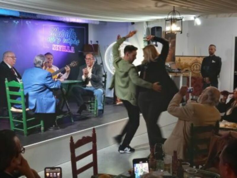Actuación musical en un local de Sevilla, con público disfrutando.