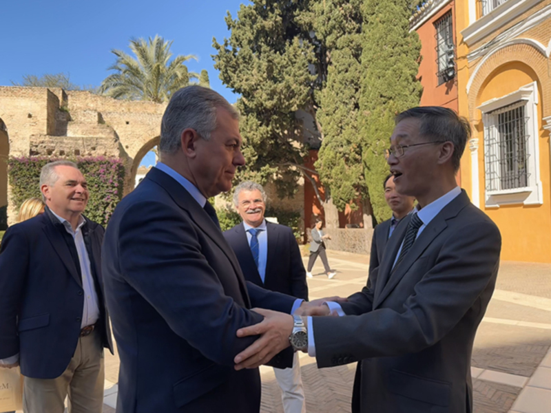 Encuentro de líderes en un patio histórico, intercambio de saludos en trajes formales.