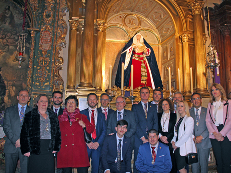 Oficialidad en un templo con la Virgen del Carmen en el fondo, posando para una foto oficial.