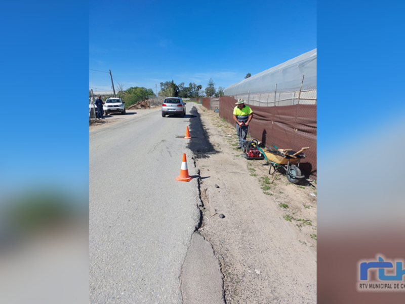 Trabajos de reparación de carretera con trabajadores y equipo de construcción.