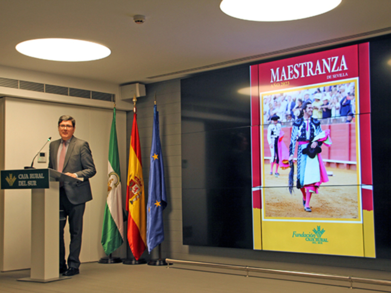 Presentación en Caja Rural del Sur sobre Maestranza de Sevilla, con banderas y pantalla de toros