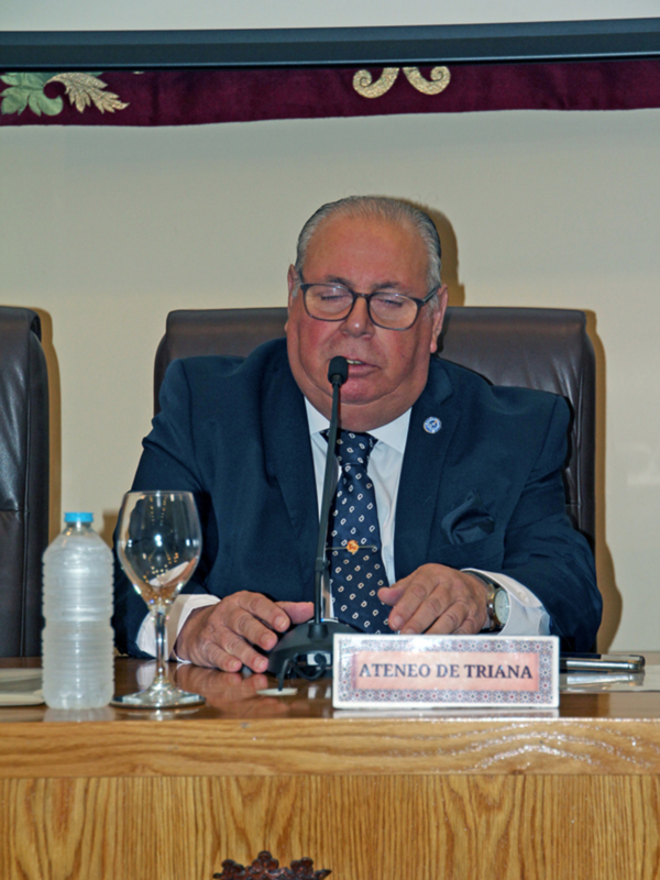 Hombre en traje hablando en un evento formal en el Ateneo de Triana.