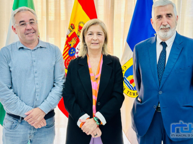 Reunión oficial con banderas de España y Andalucía en el fondo.