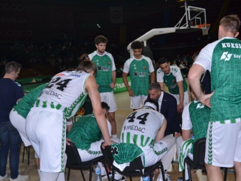 Equipo de baloncesto en una reunión táctica durante un partido en Sevilla.