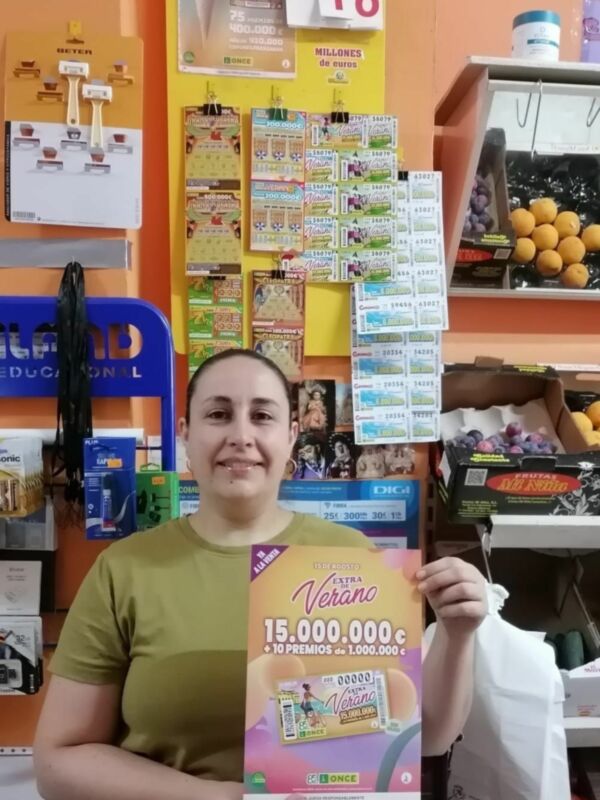Persona sosteniendo un boleto de lotería 'Verano de 15.000.000 €' en un establecimiento comercial.