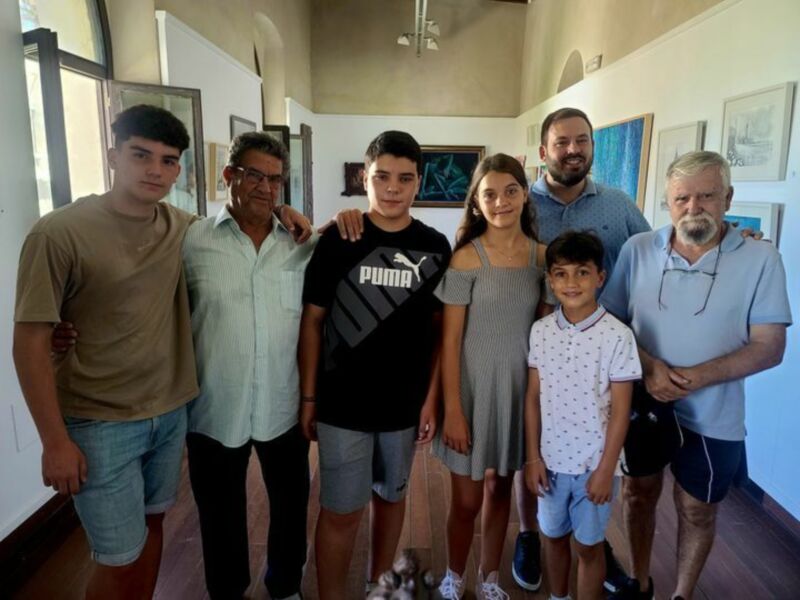 Una familia reunida en un ambiente acogedor, con retratos y arte en el fondo.