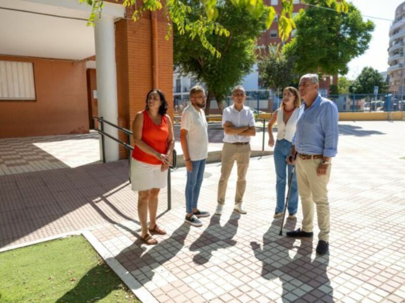 Grupo de personas conversando en un entorno urbano, posiblemente en una zona de trabajo o reunión.