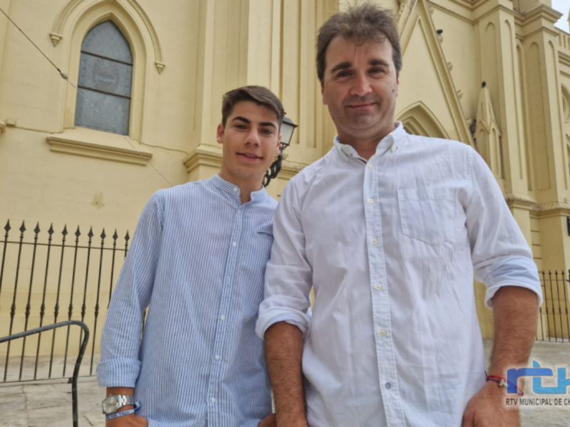 Dos personas posan frente a una iglesia con arquitectura neogótica.