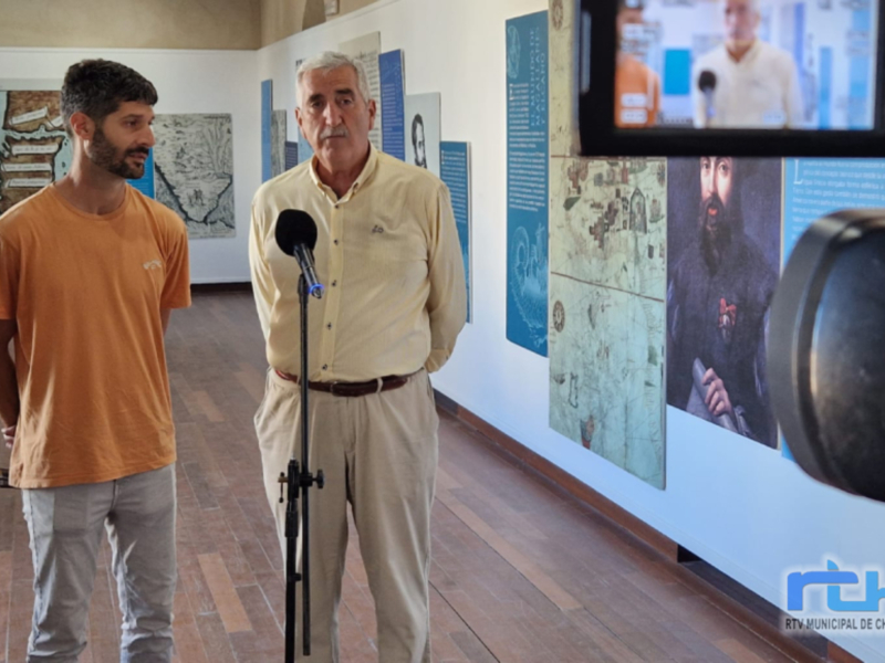 Entrevista en el Museo de Chipiona, con paneles históricos y una pantalla de video en el fondo.