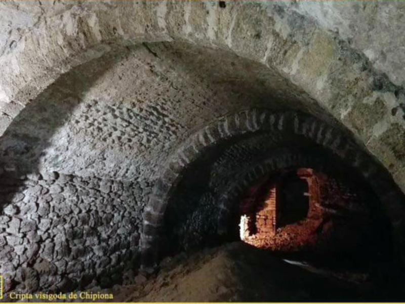 Interior de la Cripta visigoda de Chipiona, con arcos de piedra y paredes antiguas.