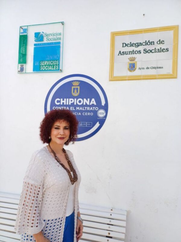 Mujer posando frente a la Delegación de Servicios Sociales de Chipiona, España.