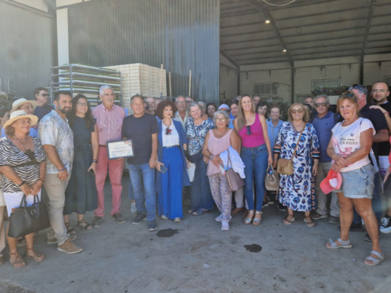 Celebración en una fábrica de madera con una reunión de personas en un hangar.