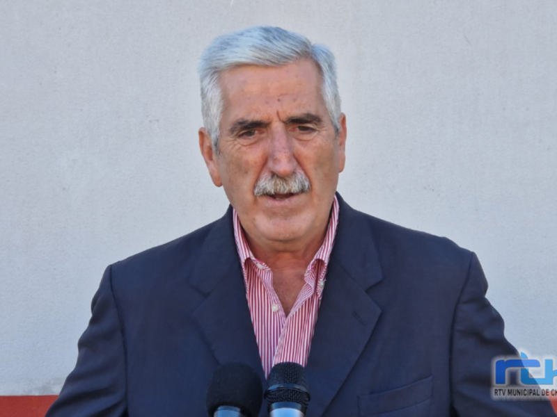 Hombre hablando en un evento público con microfonos frente a él.