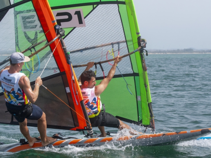 Competencia de windsurf en el mar con dos participantes en acción.