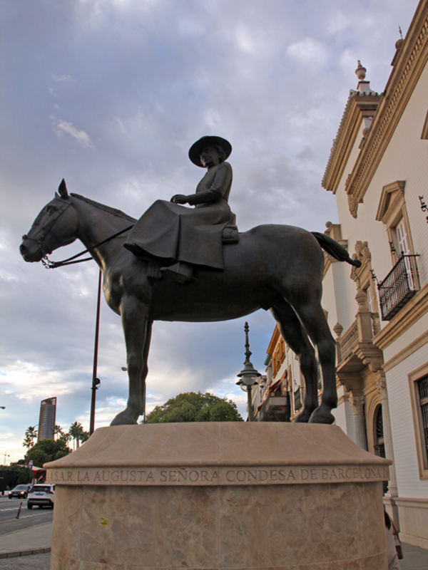 Estatua ecuestre de la Condesa de Barcelona, ubicada en una plaza con edificios históricos al fondo.