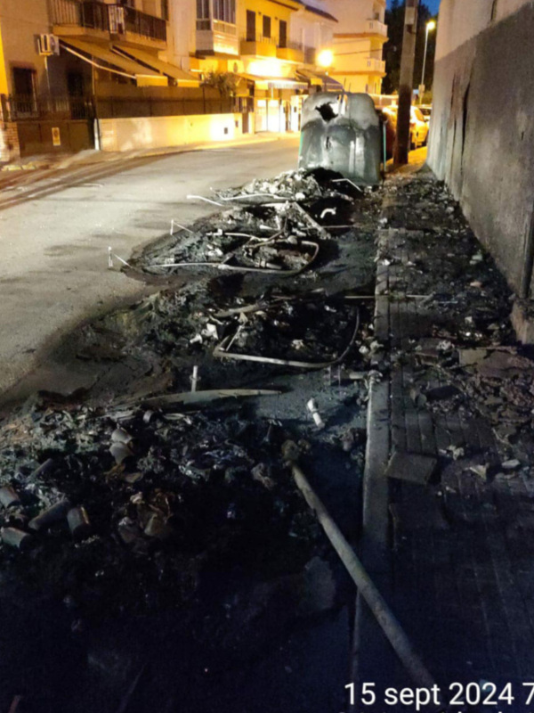 Derrumbe de una estructura en la acera de una calle urbana, con escombros y cables expuestos.