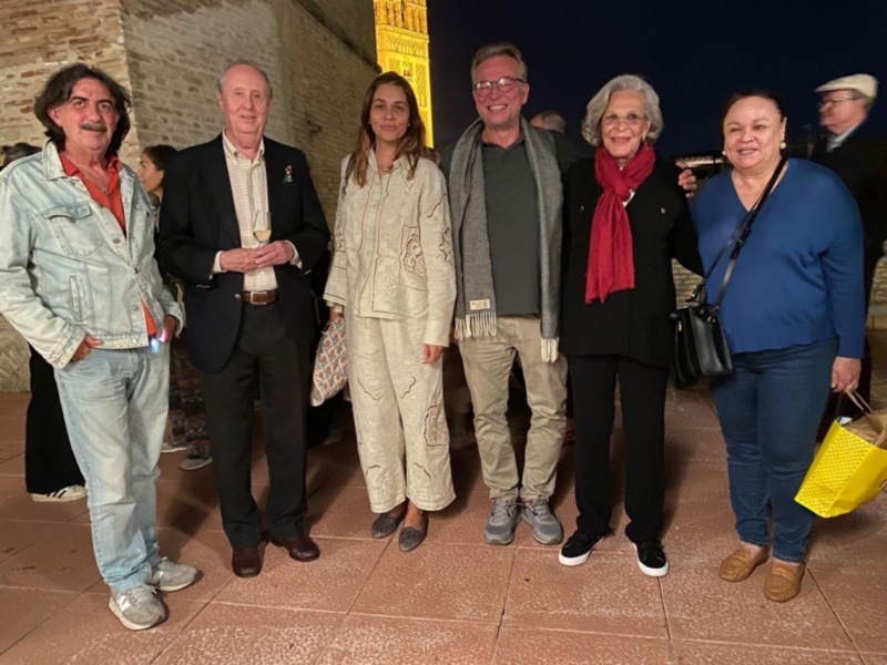 Una reunión de amigos en una noche estrellada, con una vista impresionante de la catedral en el fondo.