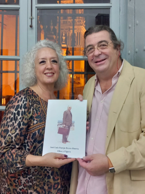 Presentación del libro 'Obra y Figura' de José Luis Parejo-Bravo Huerta, en un ambiente acogedor con vistas a una catedral iluminada.