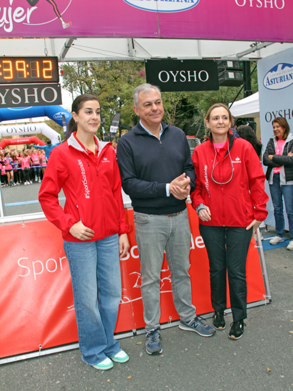 Personas posando frente a un cartel con la marca OYSHO en una carrera o evento deportivo.