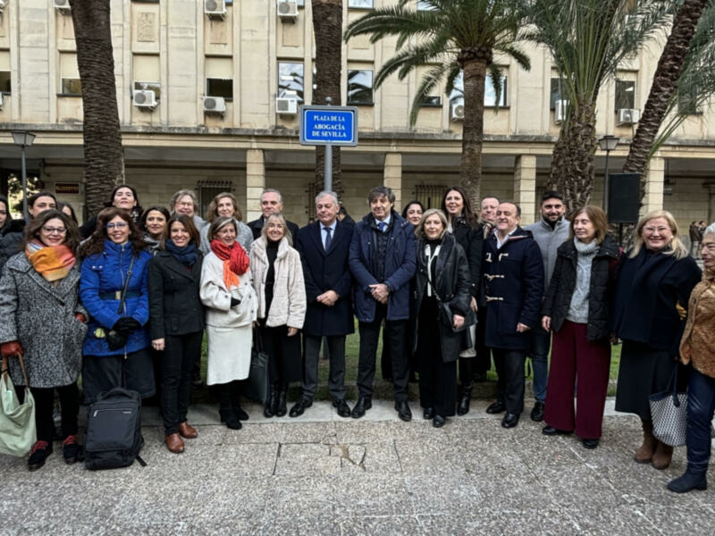 Gruppo di persone in posa per una foto di gruppo davanti all'edificio dell'Abogacía de Sevilla.