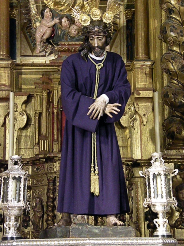 Estatua de Jesús Nazareno en traje morado, coronado de espinas, en un altar ornamental con detalles dorados.