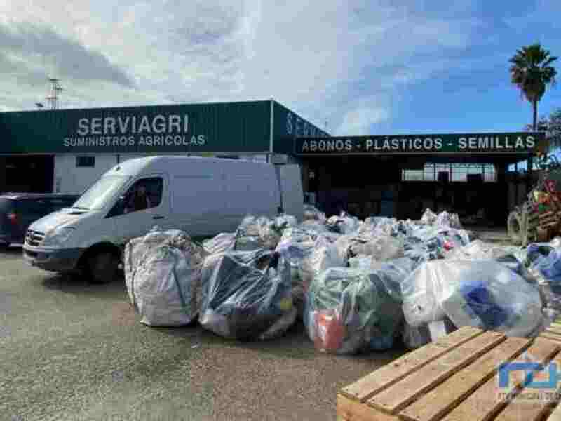 Servicios agrícolas en un entorno industrial con bolsas de plástico y una furgoneta.