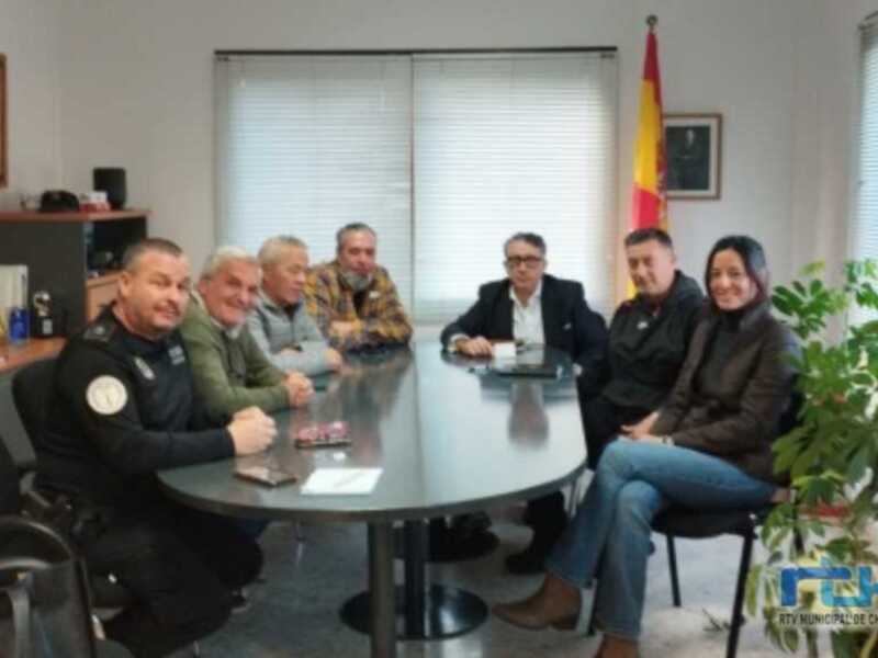 Reunión de trabajo en una oficina municipal, con participantes sentados alrededor de una mesa.