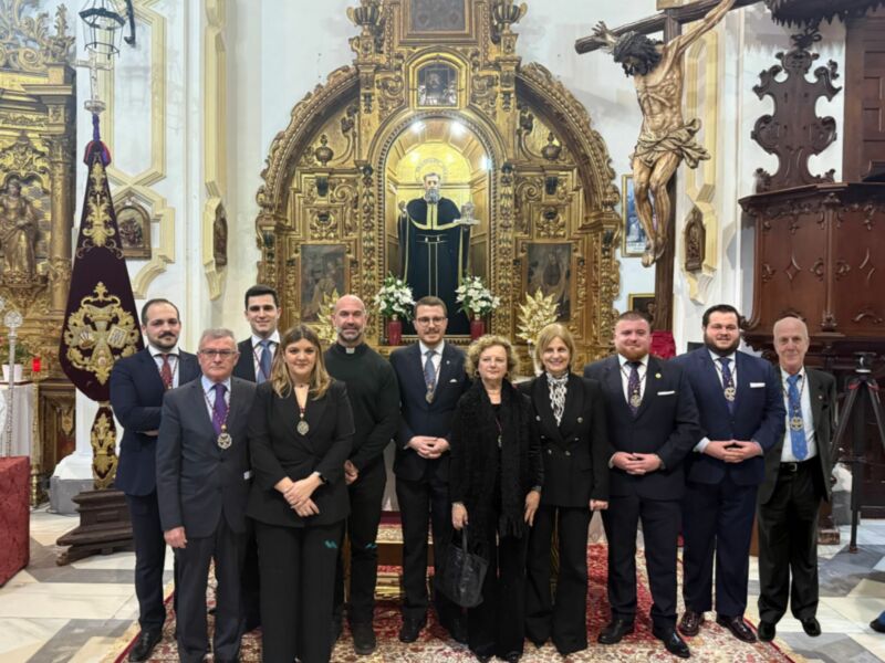Grupo de personas posando en una iglesia con un altar dorado y una imagen de San Antonio de Padua en el fondo.