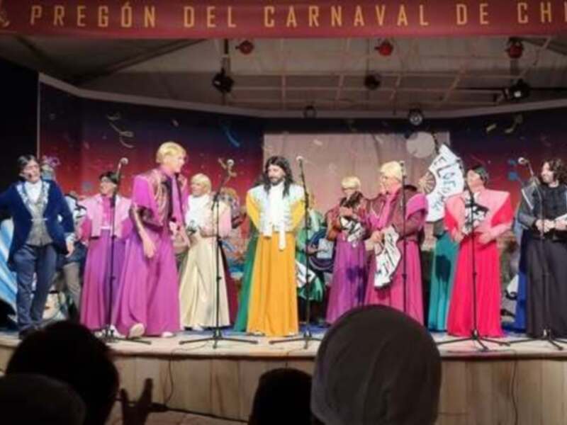 Actores en trajes coloridos en el escenario durante el pregón del Carnaval de Chipiona.