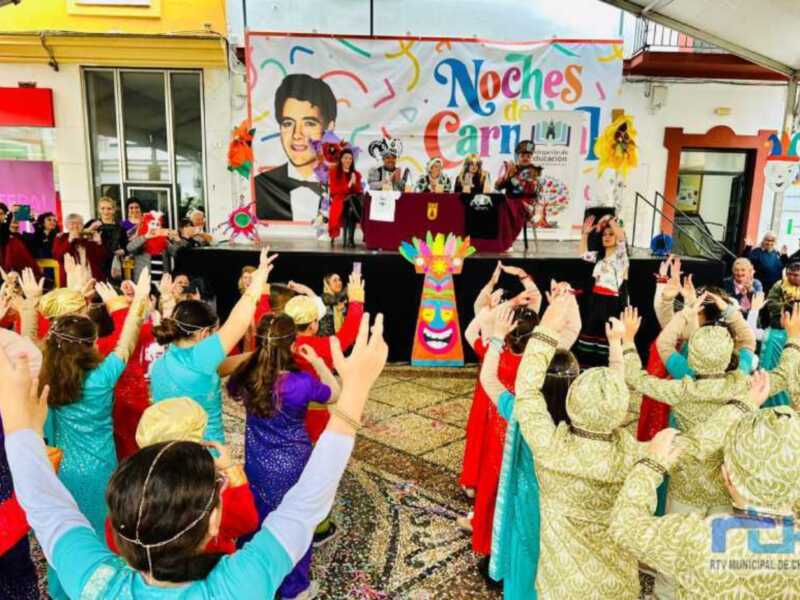 Celebración del Carnaval en Chipiona con niños en trajes coloridos y público animado.