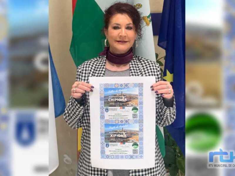 Mujer sosteniendo un cartel promocional de Chipiona, España, con detalles sobre el Festival de la Alcachofa y el Festival de la Cerveza.