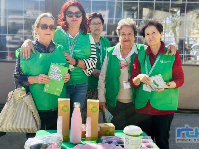 Voluntarias de una organización de salud promueven la detección temprana del cáncer de colon en un evento público.