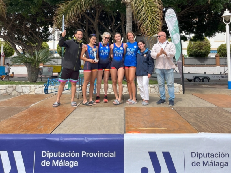 Equipo de remo RCM 1873 celebrando una victoria en un evento deportivo.