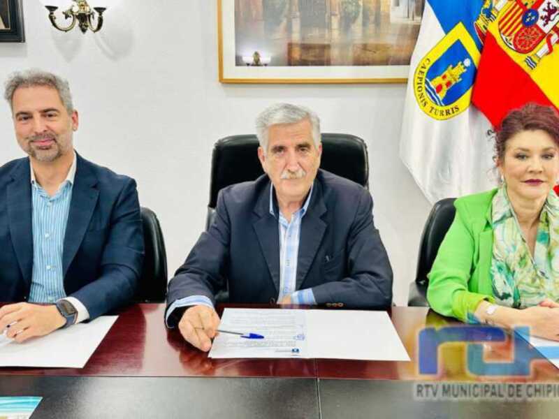 Reunión oficial en el Ayuntamiento de Chipiona, con representantes municipales firmando documentos.