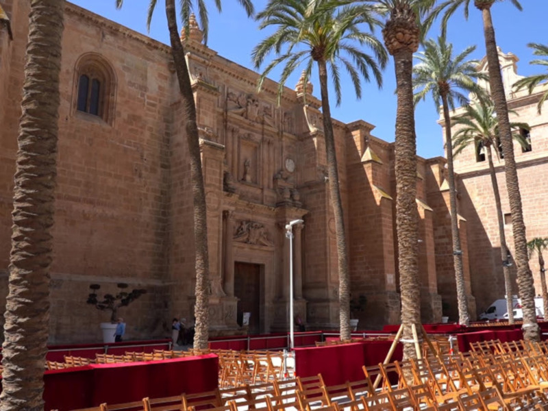 Catedral con palmeras en el frente, durante un evento público.
